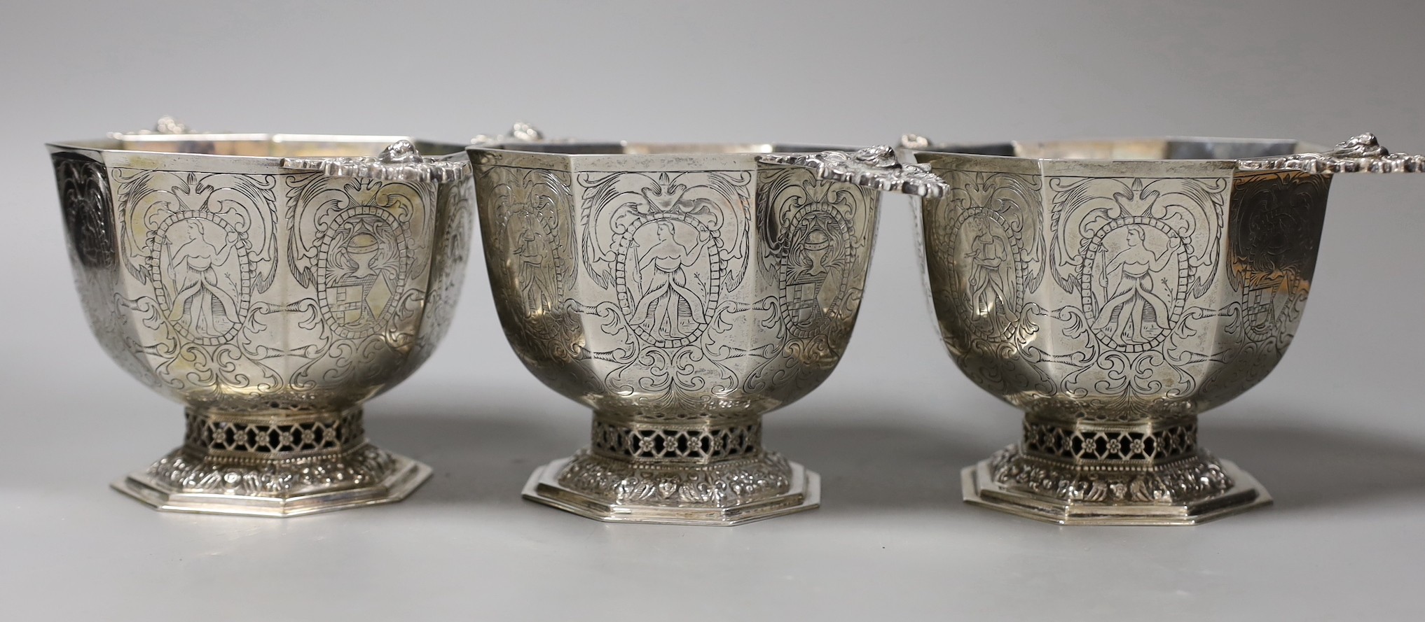 A set of three 19th century Dutch 833 standard white metal octagonal twin mask handled octagonal pedestal bowls, height 10cm, 35.9 oz.